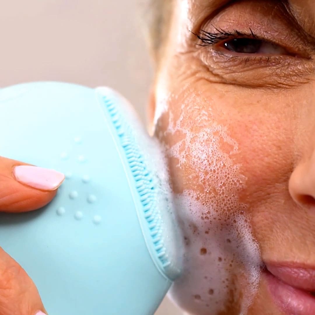 Donna matura idrata il suo viso lavandolo con SONIC FACIAL CLEANSER